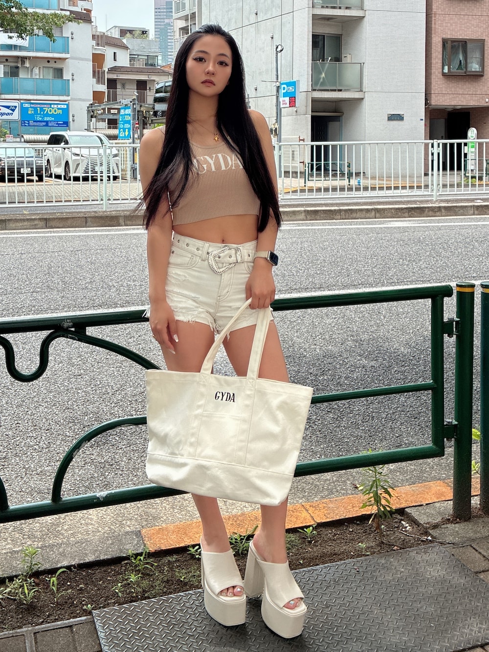 ベージュ系のキャミソール、ホワイト系のデニムパンツ、ホワイト系のサンダルを着用したレディースの夏コーディネートの1枚目の写真