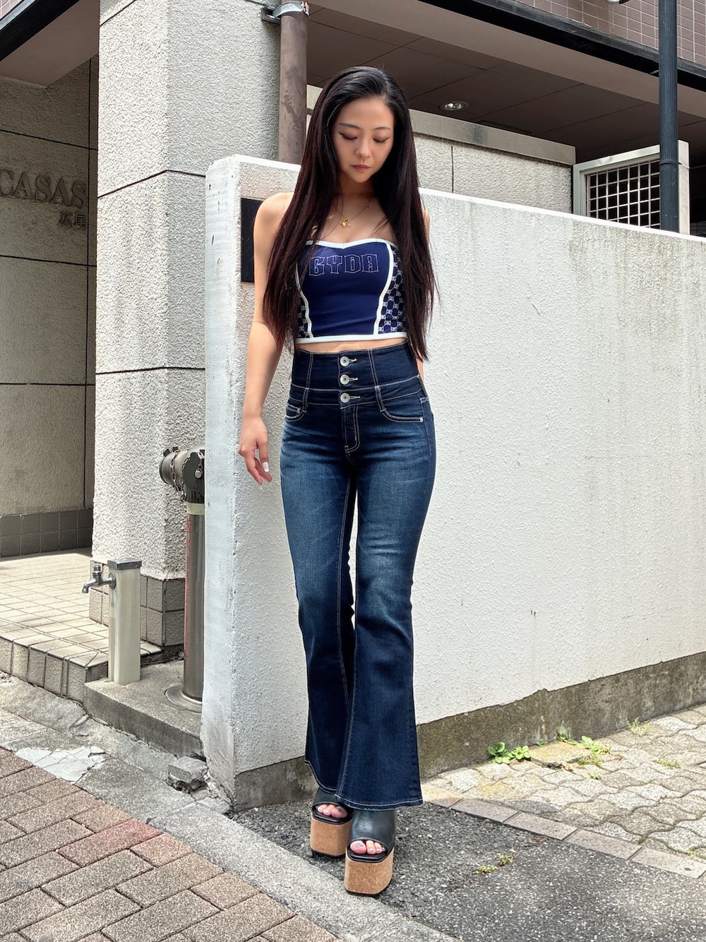 ブルー系のチューブトップ、ブルー系のデニムパンツ、ブラック系のサンダルを着用したレディースの夏コーディネートの1枚目の写真
