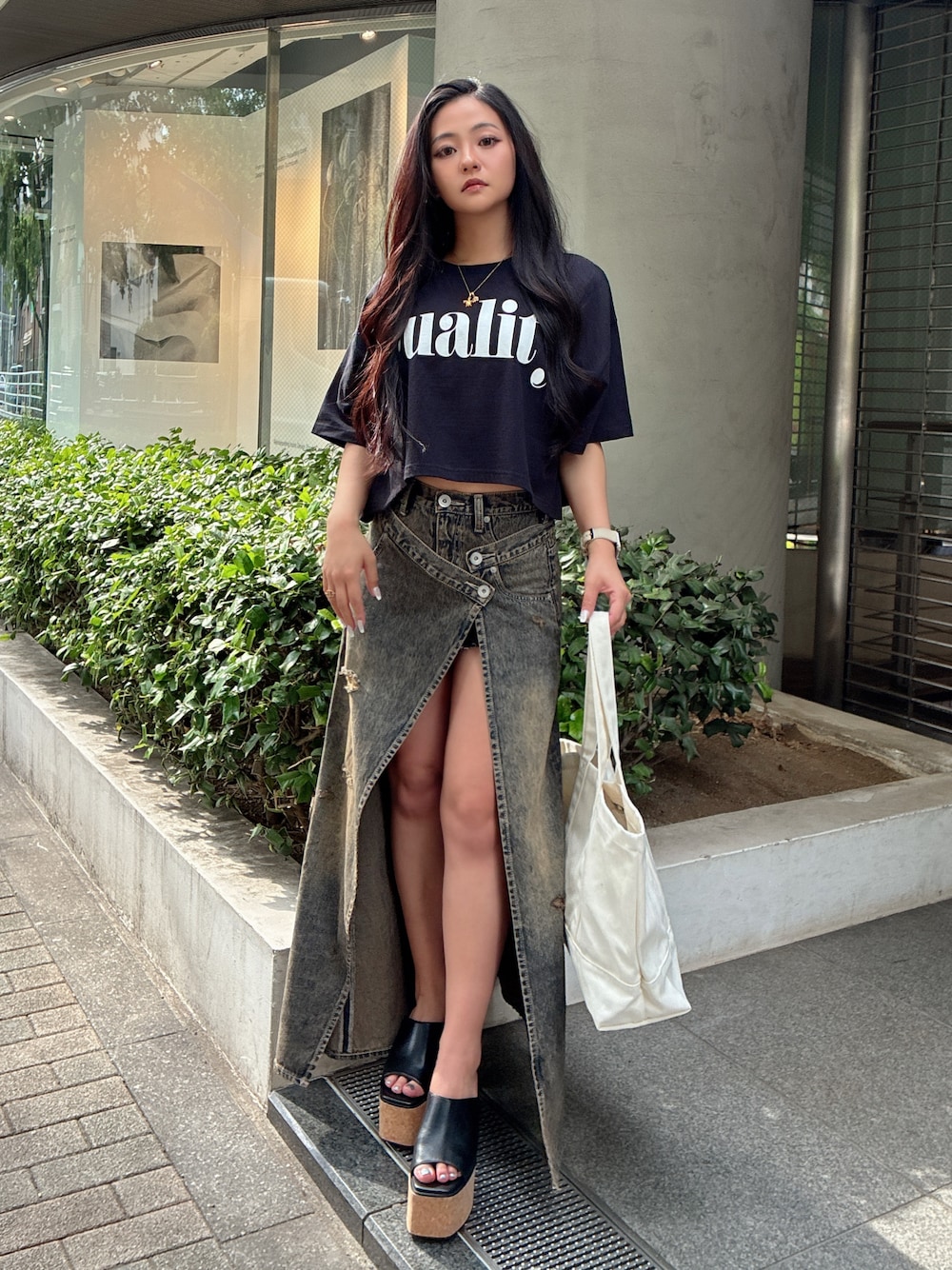 ブラック系のTシャツ/カットソー、ブルー系のデニムスカート、ブラック系のサンダルを着用したレディースの夏コーディネートの1枚目の写真