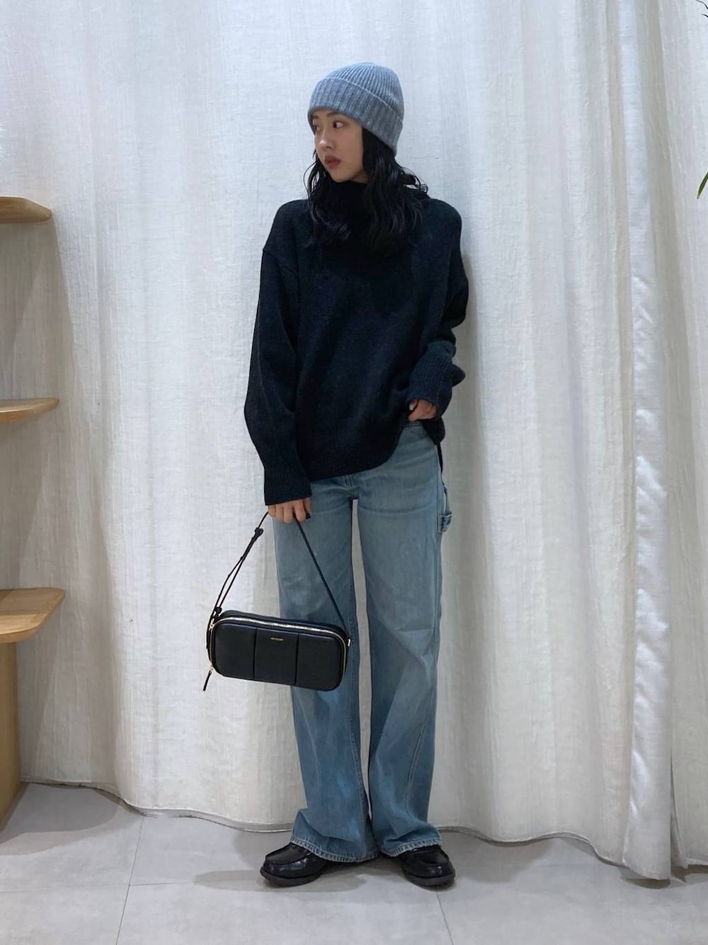 グレー系のニット/セーター、ブルー系のデニムパンツ、グレー系のニットキャップ/ビーニーを着用したレディースの冬コーディネートの1枚目の写真