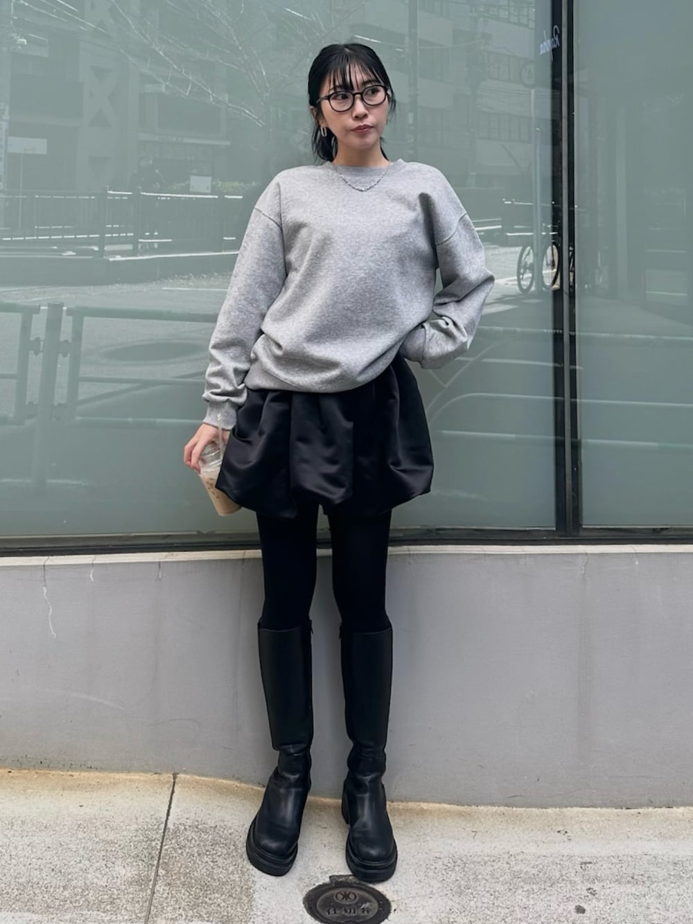 ブラック系のブーツ、ブラック系のスカート、グレー系のスウェットを着用したレディースの冬コーディネートの1枚目の写真