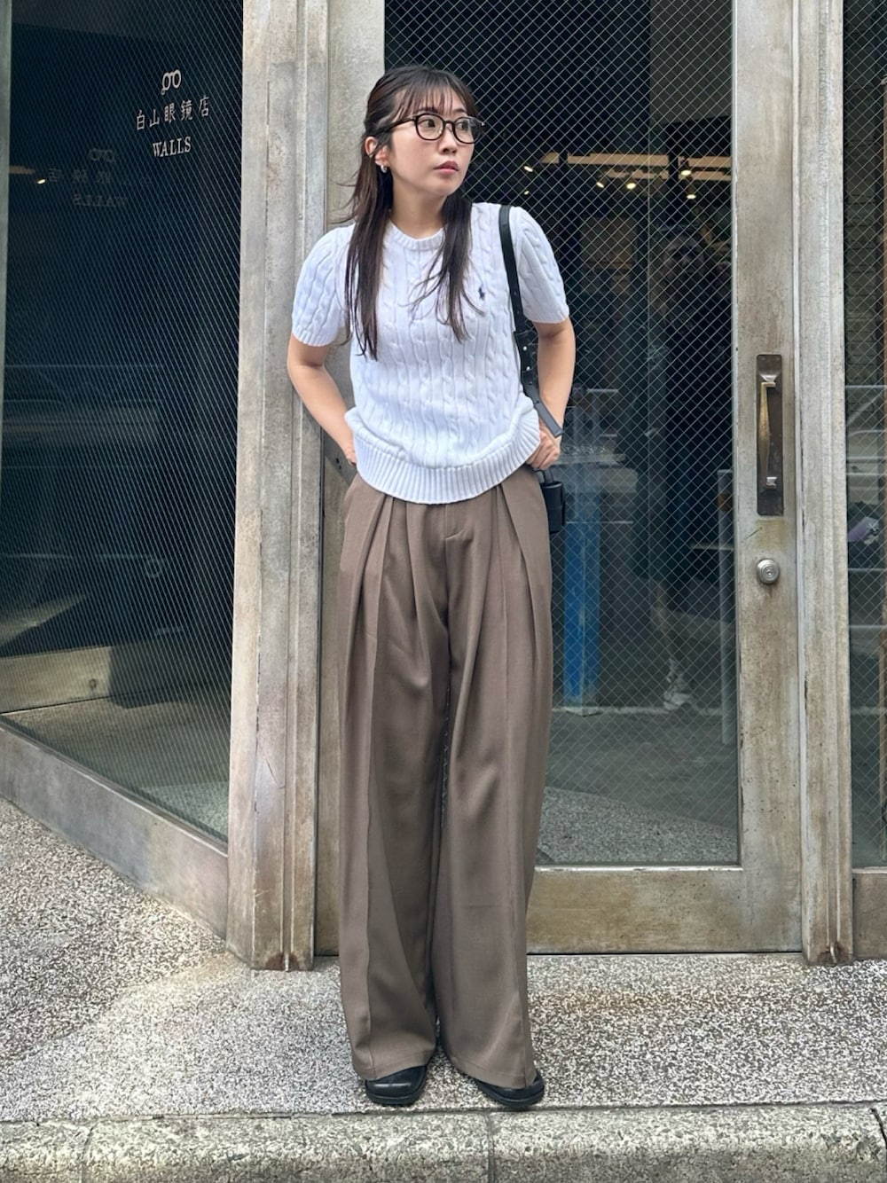 ホワイト系のニット/セーター、ブラック系のブーツ、ブラウン系のスラックスを着用したレディースの秋コーディネートの1枚目の写真