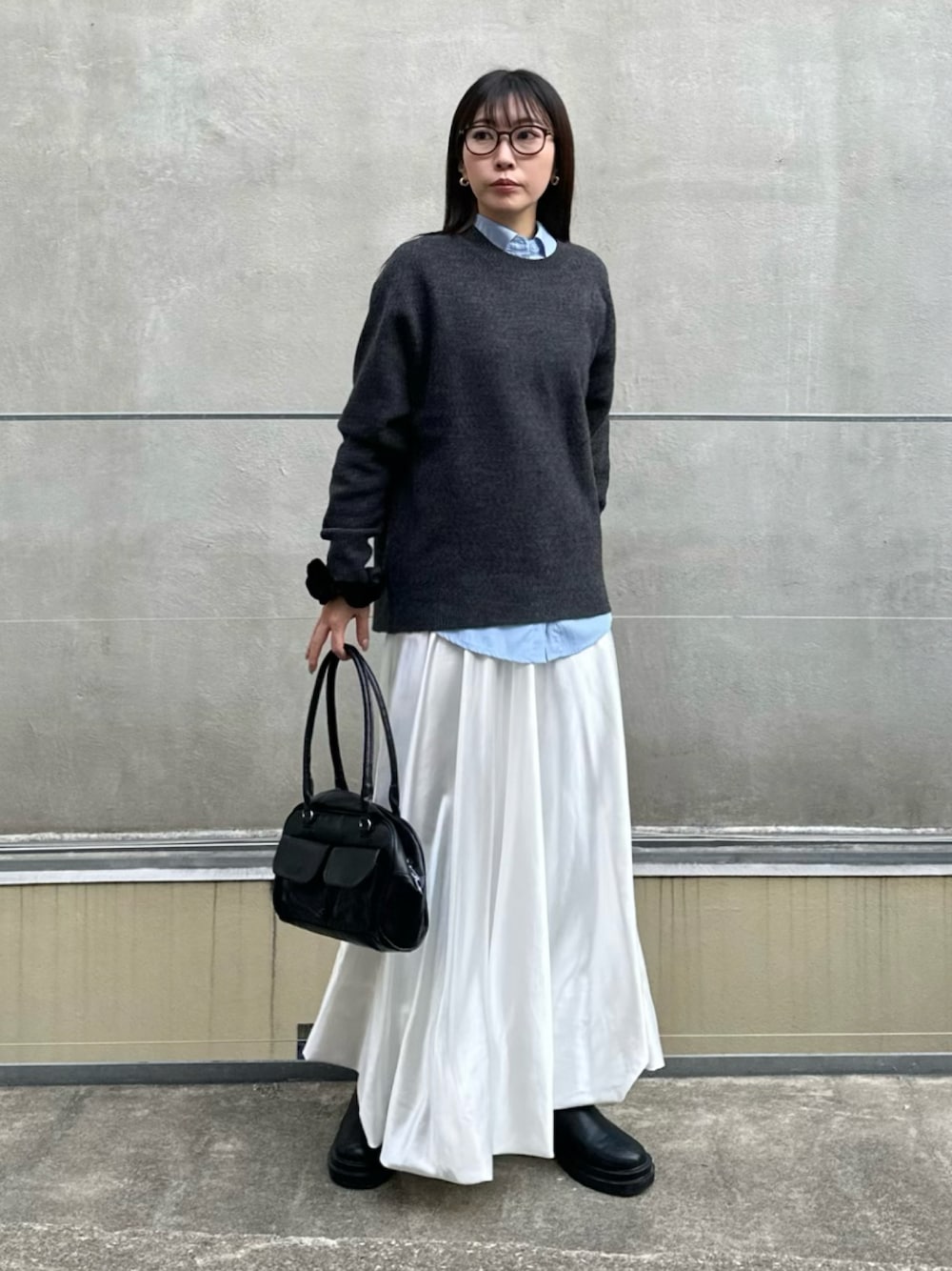 ホワイト系のスカート、ブラック系のブーツ、グレー系のニット/セーターを着用したレディースの冬コーディネートの1枚目の写真