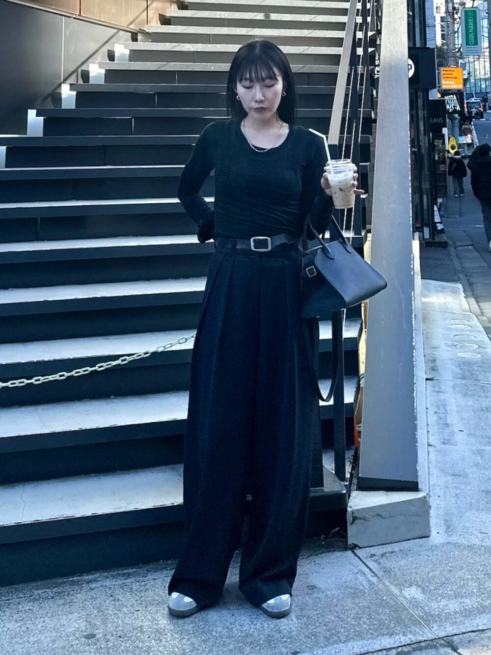 ブラック系のハンドバッグ、ホワイト系のスニーカー、ブラック系のその他パンツを着用したレディースの春コーディネートの1枚目の写真