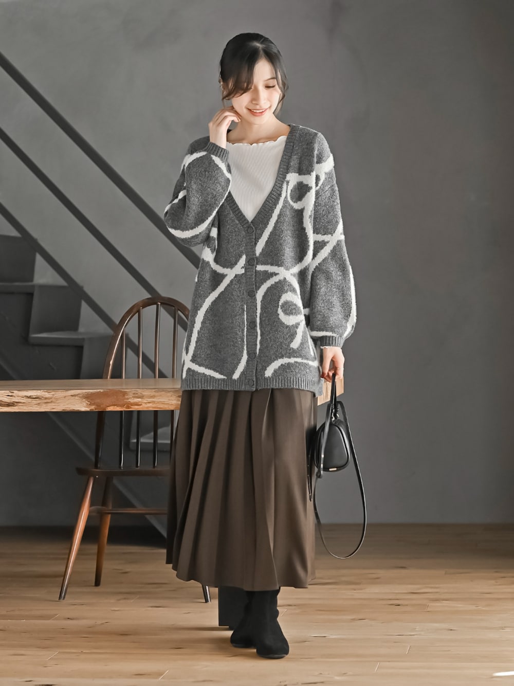ブラウン系のスカート、グレー系のカーディガン/ボレロを着用したレディースの秋コーディネートの1枚目の写真