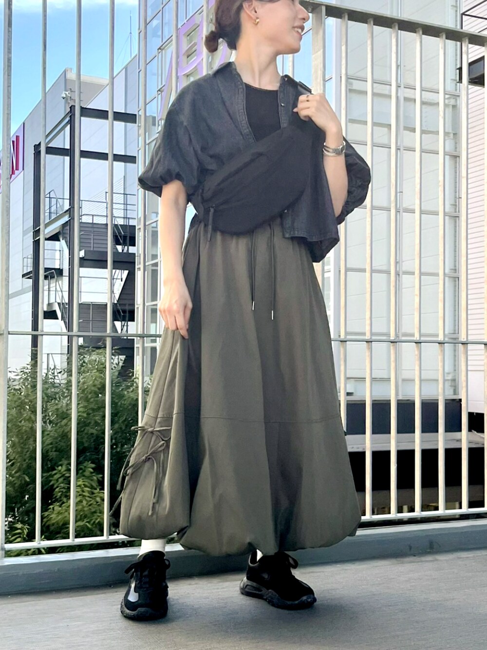 グリーン系のスカートを着用したレディースの夏コーディネートの1枚目の写真