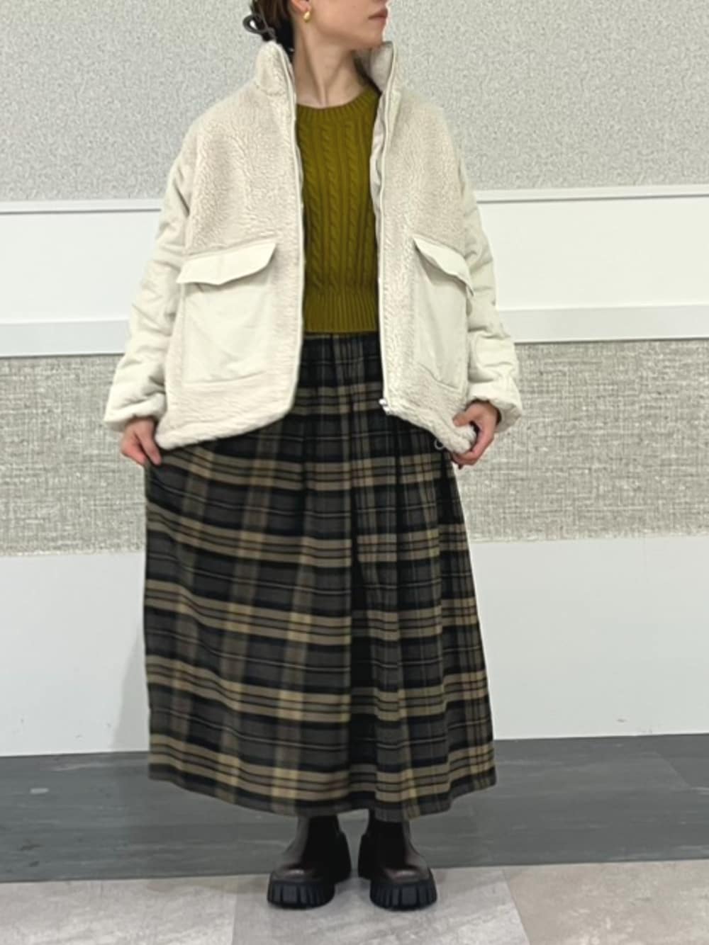 ベージュ系のダウンジャケット/コート、イエロー系のニット/セーター、ベージュ系のスカートを着用したレディースの秋コーディネートの1枚目の写真