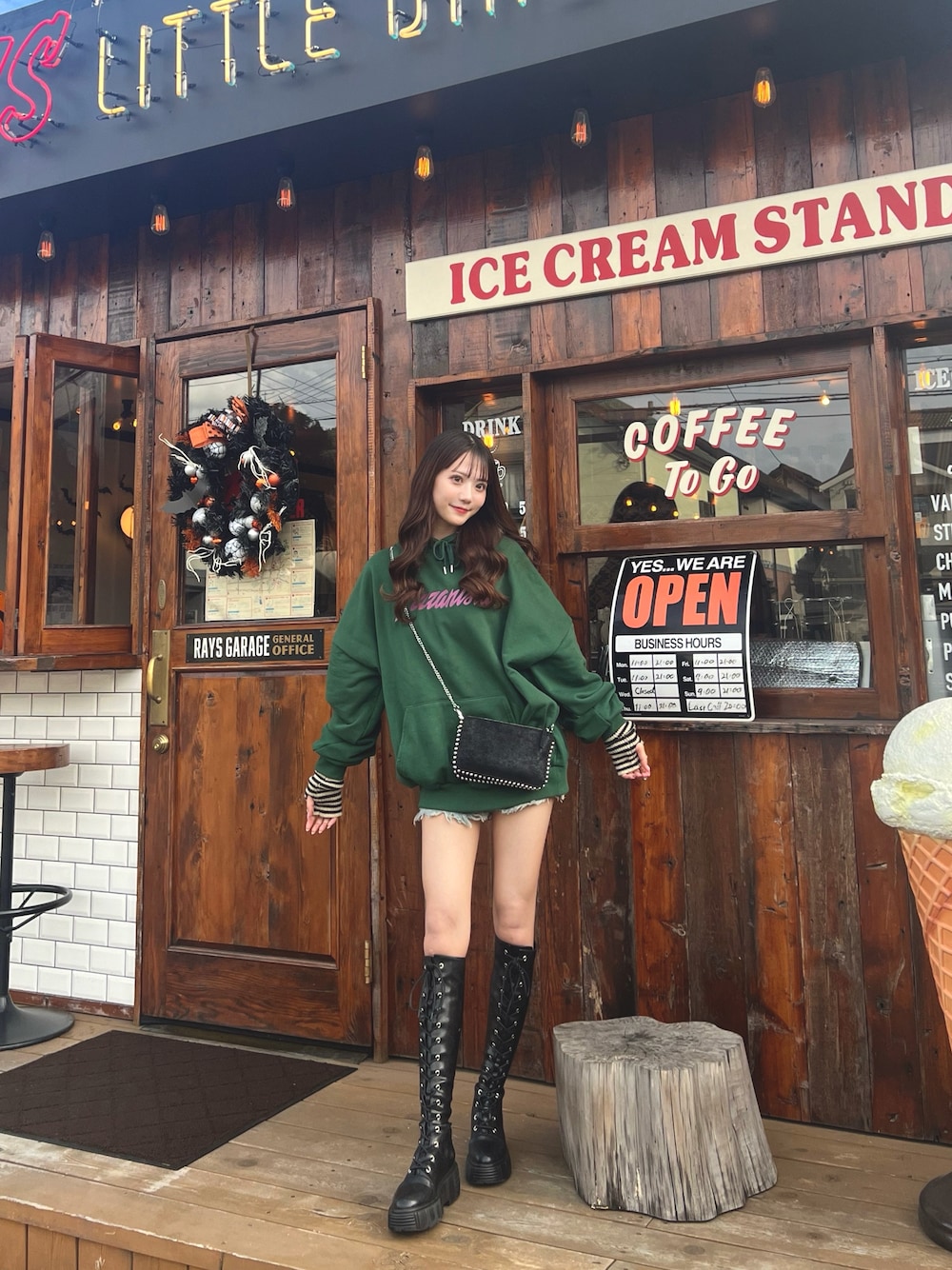 グリーン系のパーカー、ブラック系のブーツを着用したレディースの冬コーディネートの1枚目の写真