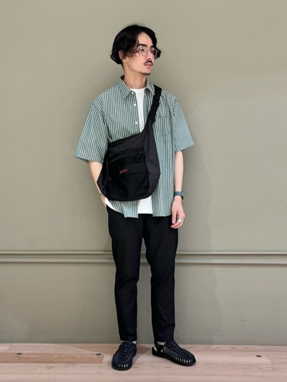 ブラック系のその他パンツ、ブラック系のサンダル、グリーン系のシャツ/ブラウスを着用したメンズの春コーディネートの1枚目の写真