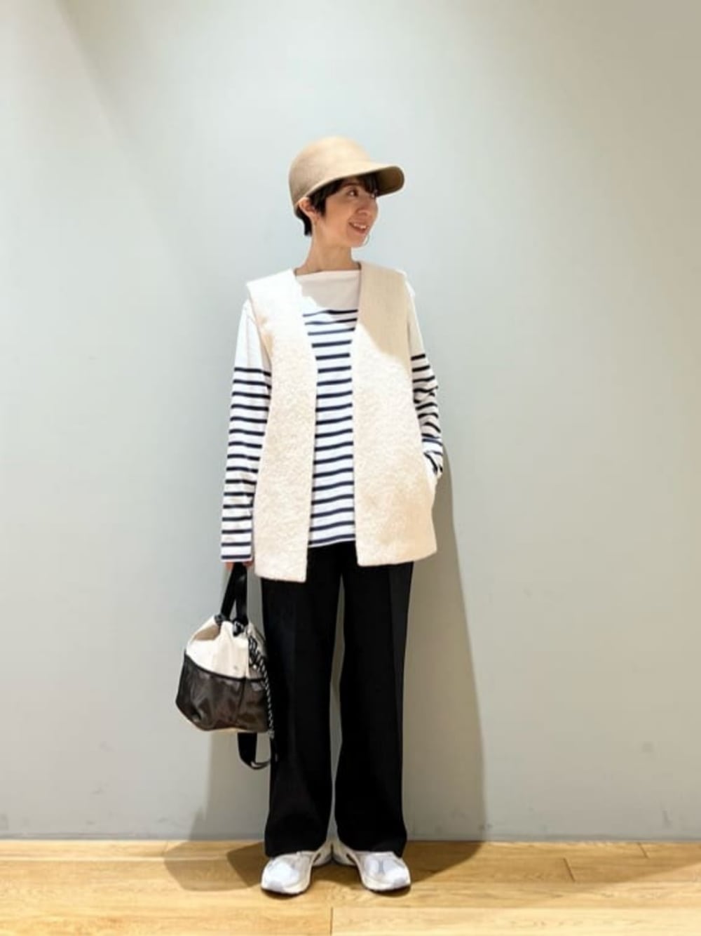 ホワイト系のスニーカー、ベージュ系のベスト、その他のTシャツ/カットソーを着用したレディースの秋コーディネートの1枚目の写真