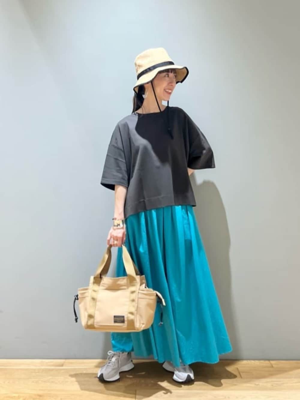 ベージュ系のトートバッグ、グレー系のスニーカー、グレー系のTシャツ/カットソーを着用したレディースの夏コーディネートの1枚目の写真