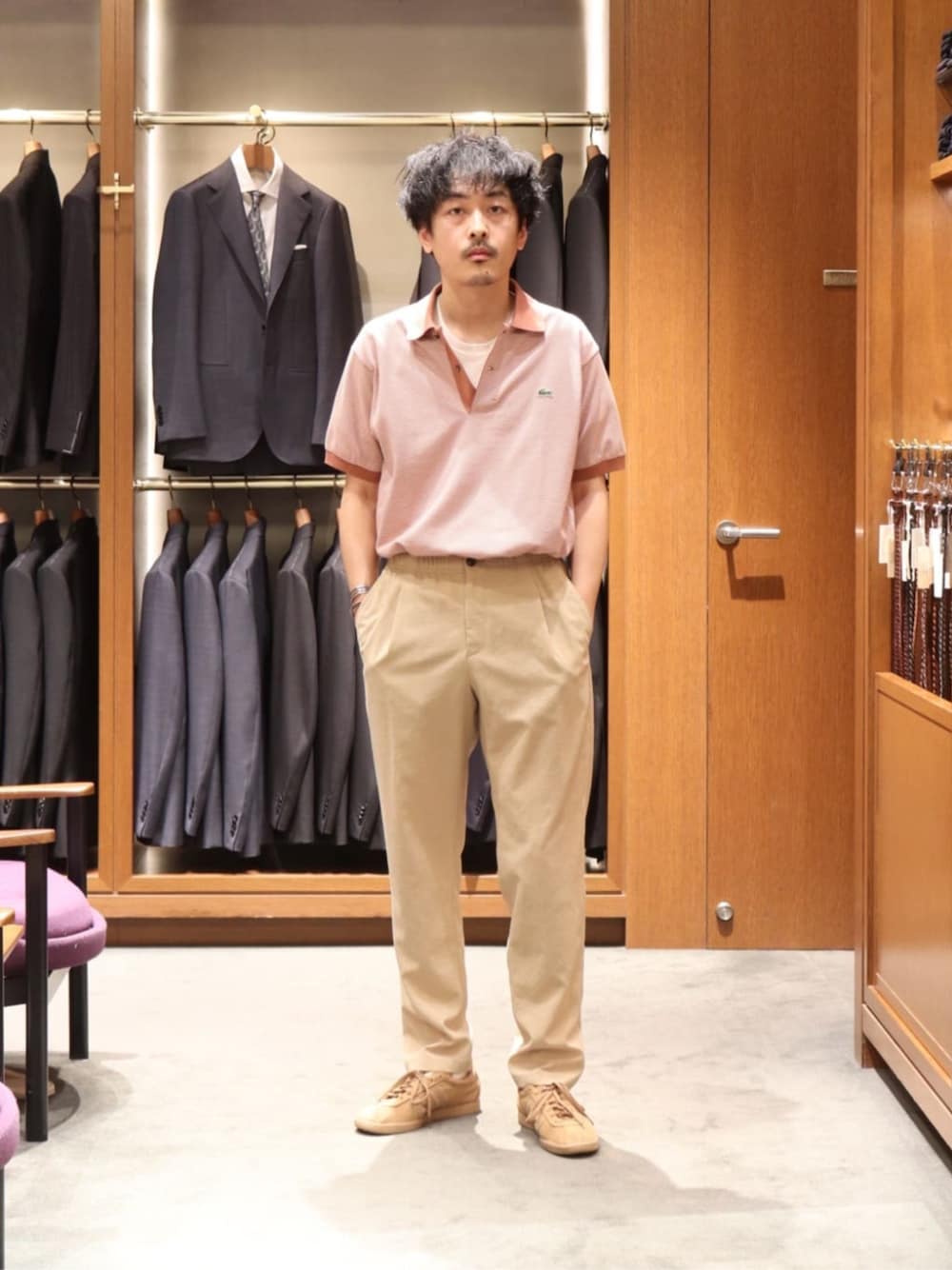 ピンク系のポロシャツ、ベージュ系のその他パンツ、ベージュ系のスニーカーを着用したメンズの夏コーディネートの1枚目の写真