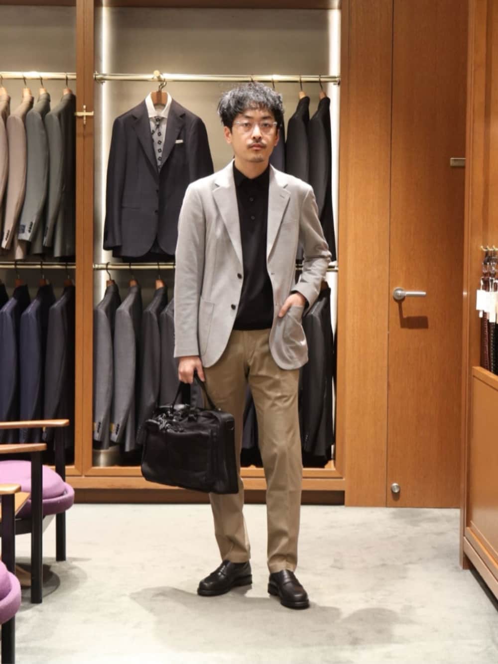 ブラック系のニット/セーター、グレー系のテーラードジャケット、ブラック系のローファーを着用したメンズの春コーディネートの1枚目の写真