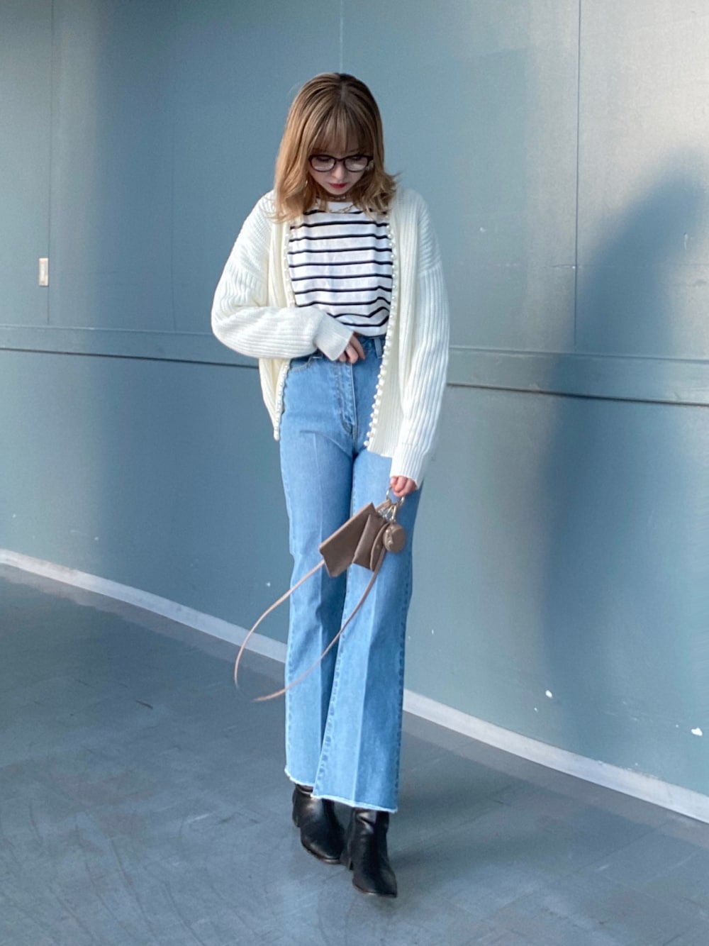 ブルー系のデニムパンツ、その他のTシャツ/カットソー、ホワイト系のカーディガン/ボレロを着用したレディースの冬コーディネートの1枚目の写真