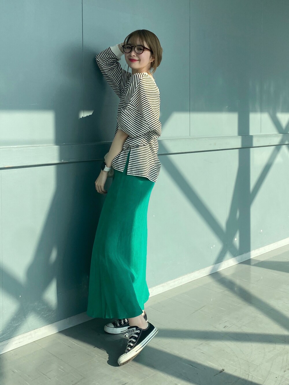 ブラック系のTシャツ/カットソー、グリーン系のスカート、ホワイト系のショルダーバッグを着用したレディースの春コーディネートの1枚目の写真