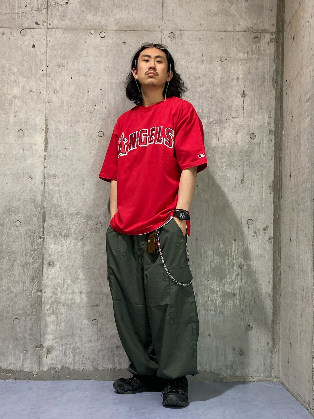 グリーン系のカーゴパンツ、レッド系のTシャツ/カットソーを着用したメンズの春コーディネートの1枚目の写真