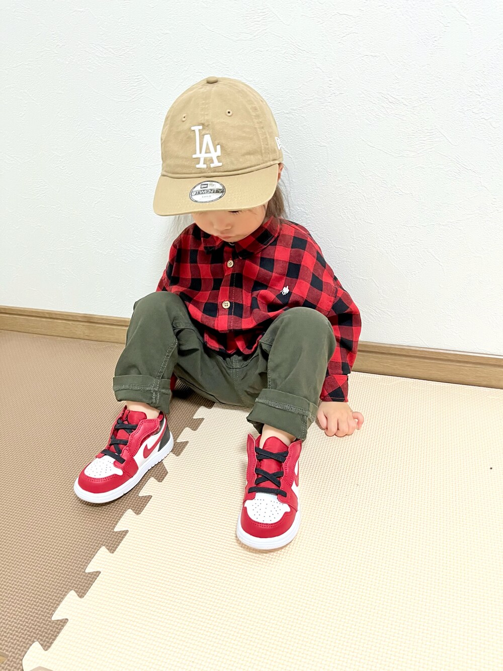 レッド系のシャツ/ブラウス、グリーン系のチノパンツ、レッド系のスニーカーを着用したキッズの春コーディネートの1枚目の写真