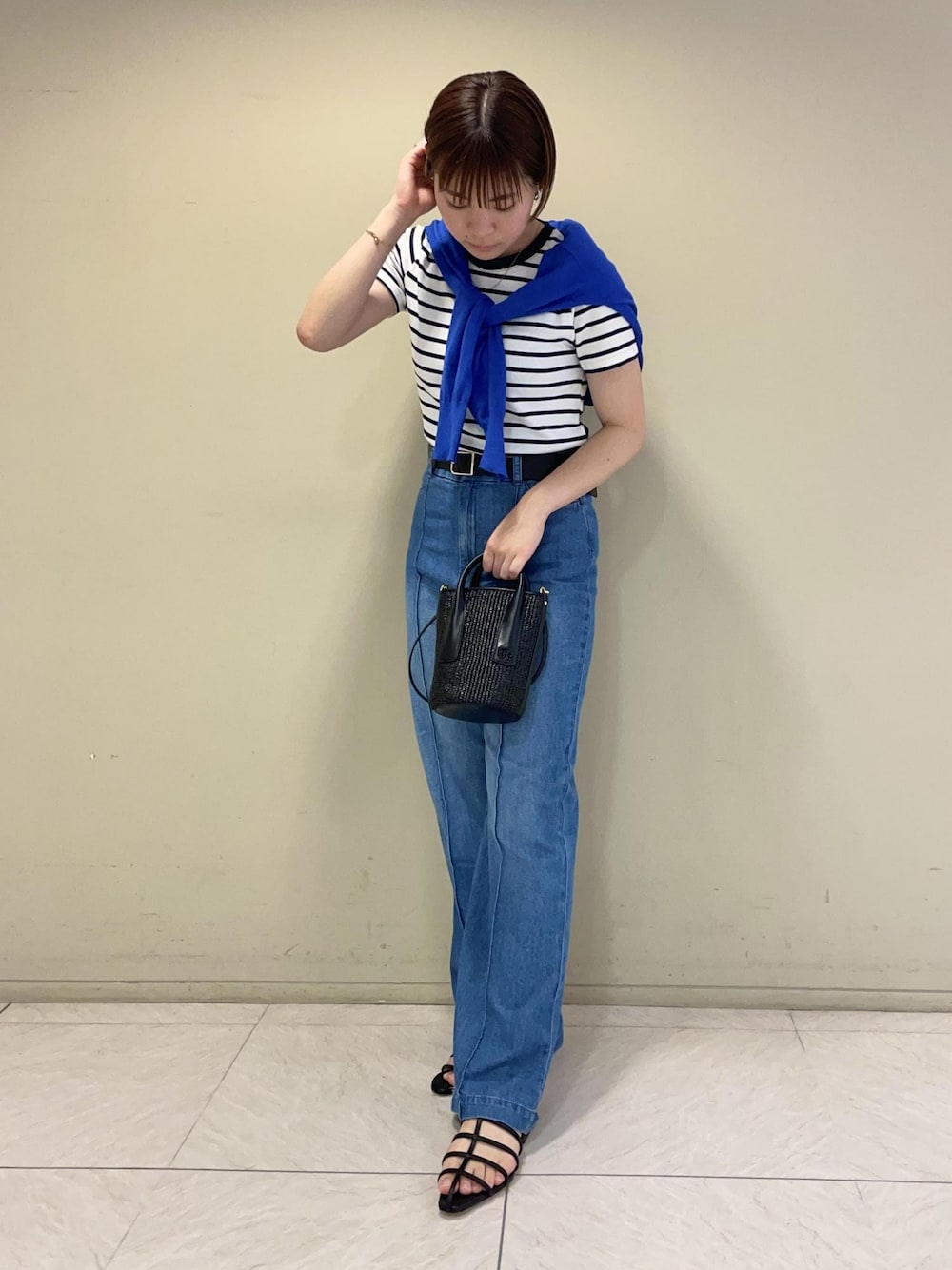 ブルー系のカーディガン/ボレロ、ブラック系のサンダル、ブラック系のハンドバッグを着用したレディースの夏コーディネートの1枚目の写真