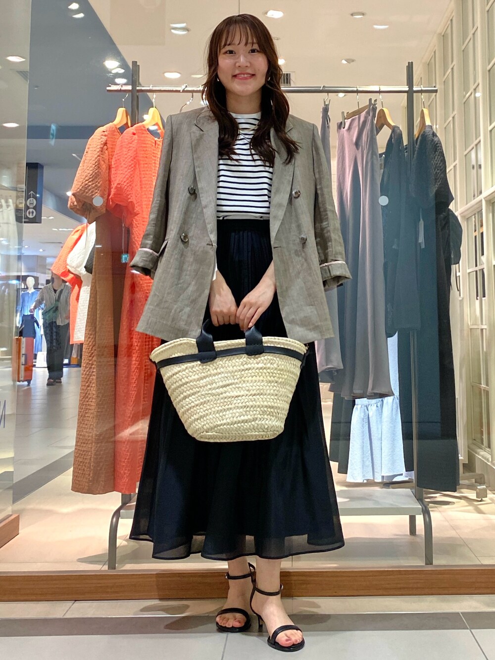 グレー系のテーラードジャケット、ピンク系のTシャツ/カットソー、ブラック系のかごバッグを着用したレディースの春コーディネートの1枚目の写真