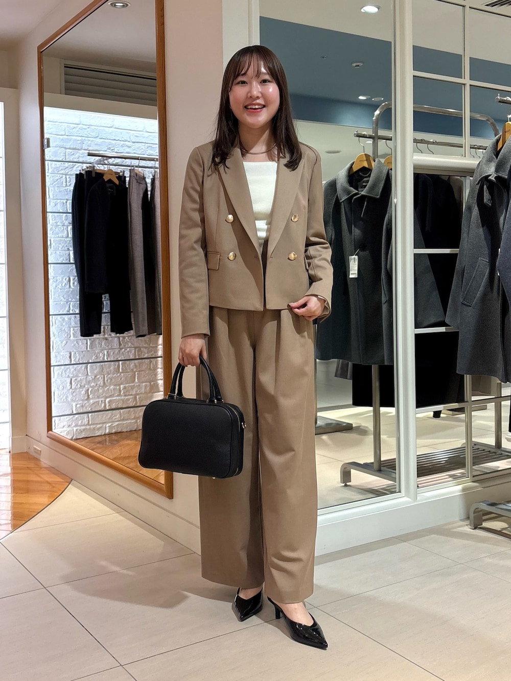 イエロー系のその他パンツ、イエロー系のテーラードジャケット、ブラック系のボストンバッグを着用したレディースの秋コーディネートの1枚目の写真