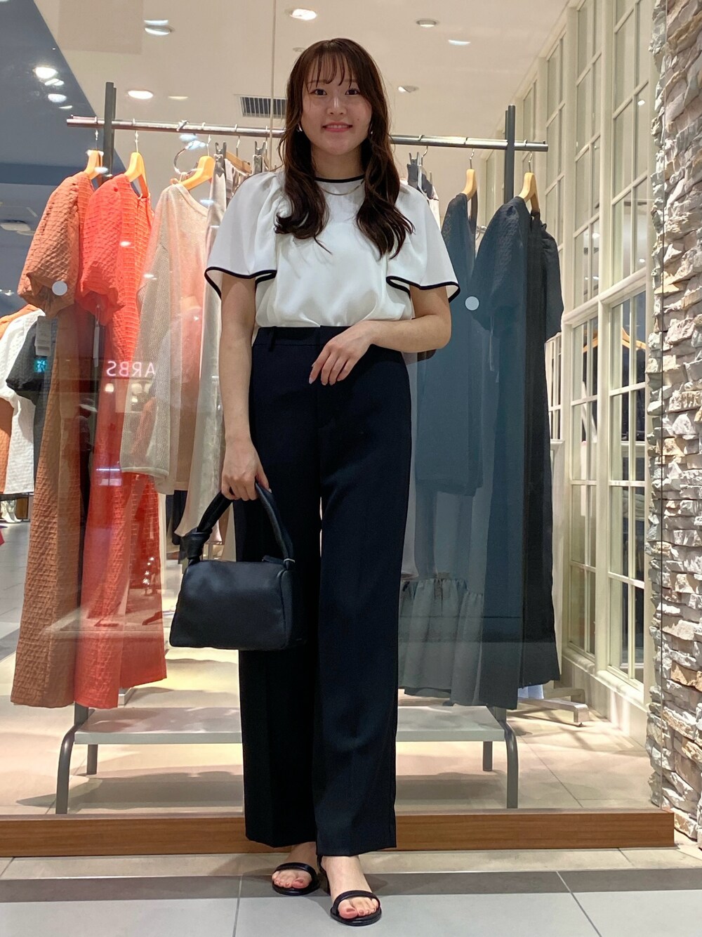 ベージュ系のその他パンツ、ブラック系のショルダーバッグ、ホワイト系のシャツ/ブラウスを着用したレディースの春コーディネートの1枚目の写真