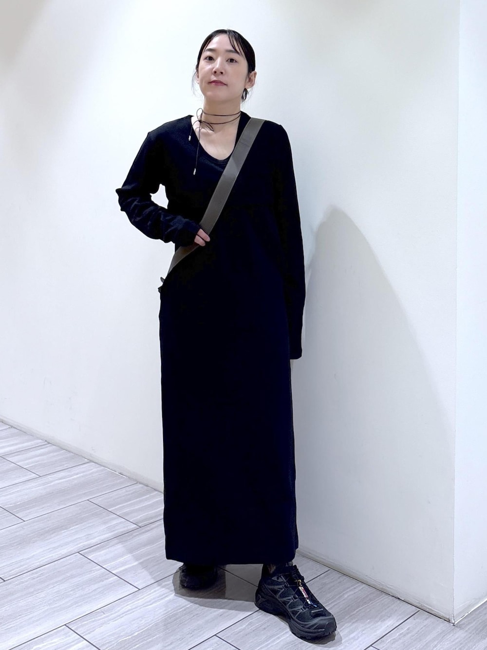 ブラック系のワンピース、ブラック系のショルダーバッグ、ブラック系のスニーカーを着用したレディースの秋コーディネートの1枚目の写真