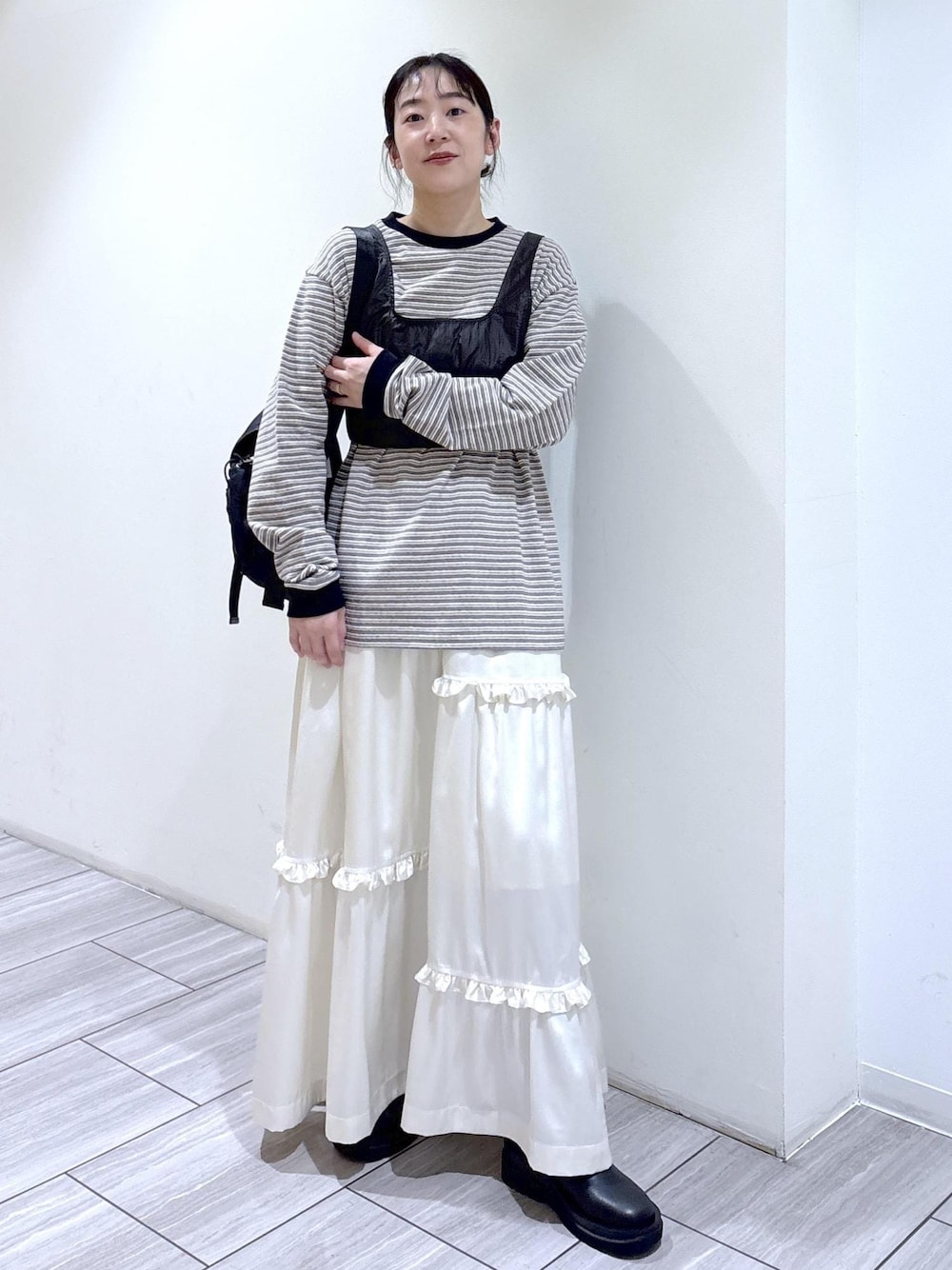 ブラック系のブーツ、ホワイト系のスカート、ホワイト系のTシャツ/カットソーを着用したレディースの冬コーディネートの1枚目の写真