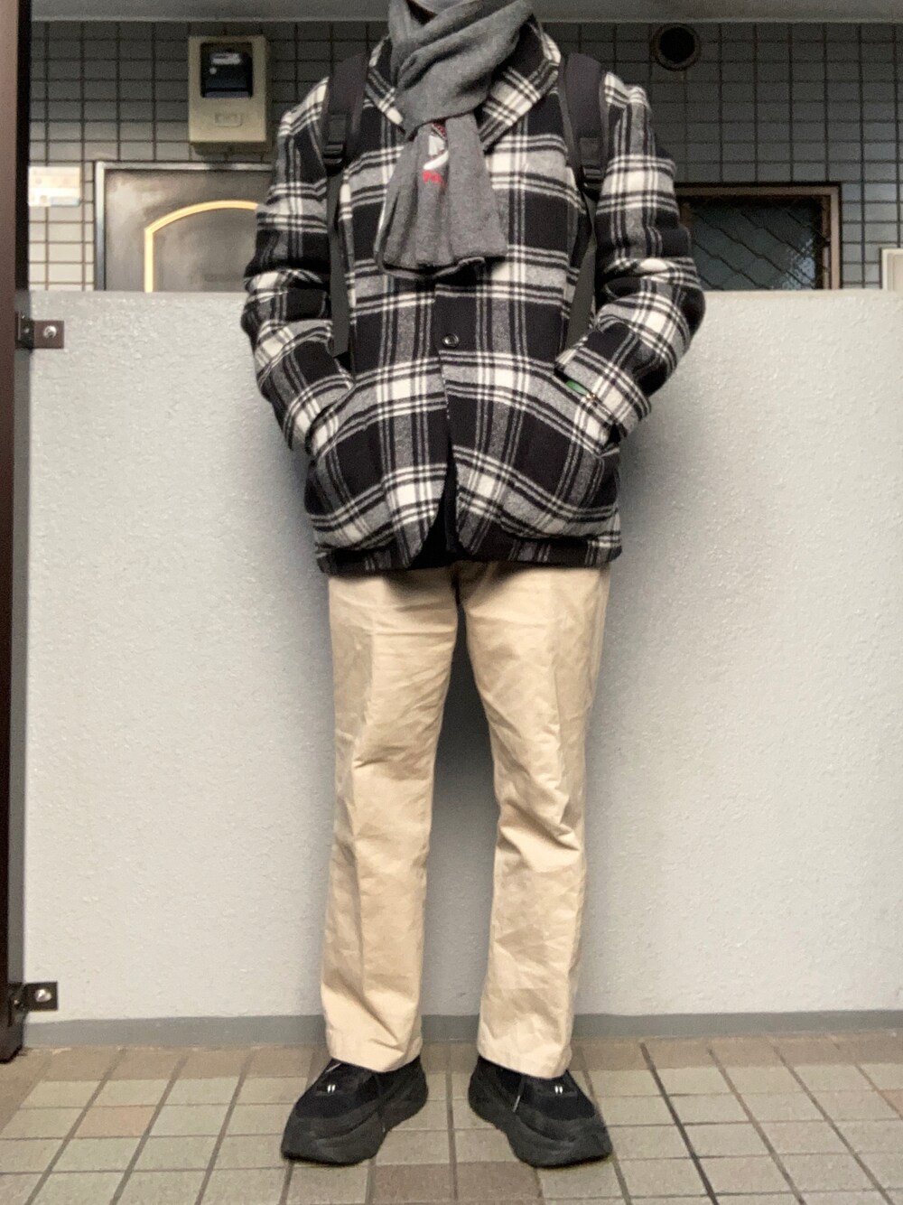 ベージュ系のチノパンツ、ブラック系のスニーカー、ブラック系のテーラードジャケットを着用したメンズの冬コーディネートの1枚目の写真