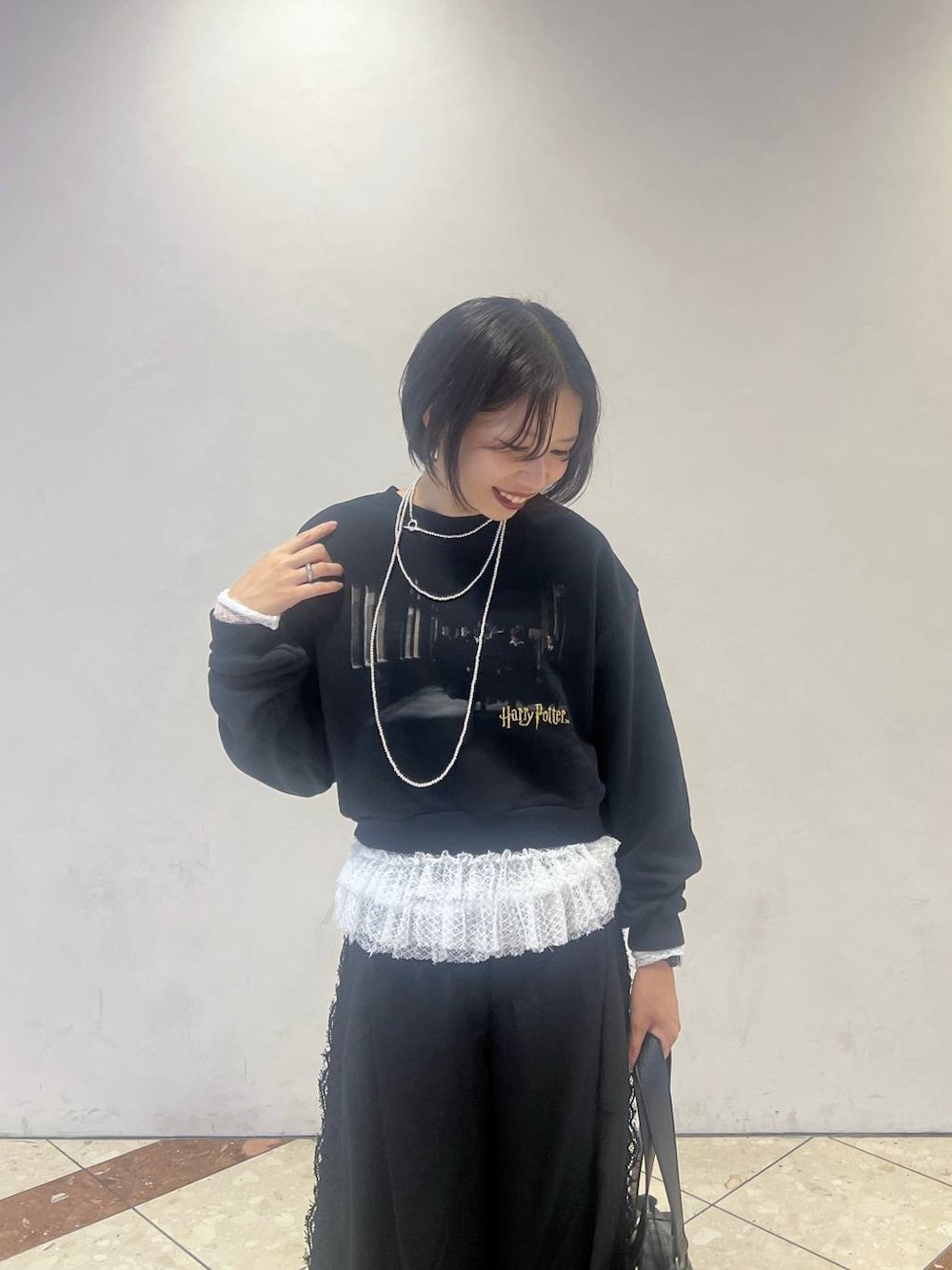 ホワイト系のTシャツ/カットソー、ブラック系のスラックス、ブラック系のスウェットを着用したレディースの秋コーディネートの1枚目の写真