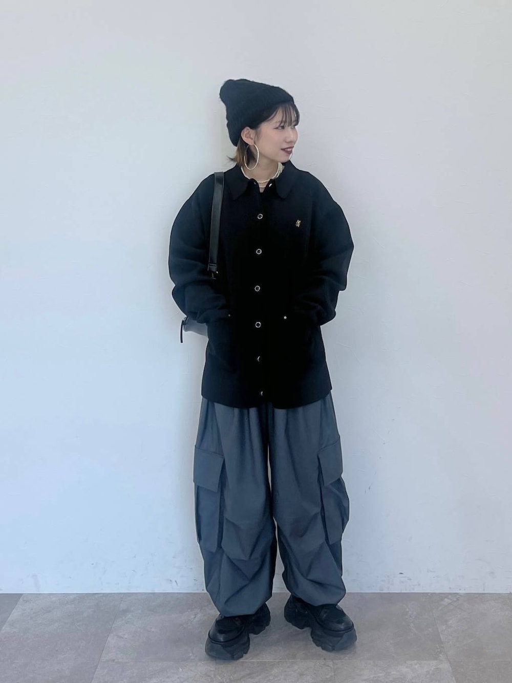 ブラック系のブーツ、グレー系のカーゴパンツ、ブラック系のカーディガン/ボレロを着用したレディースの冬コーディネートの1枚目の写真