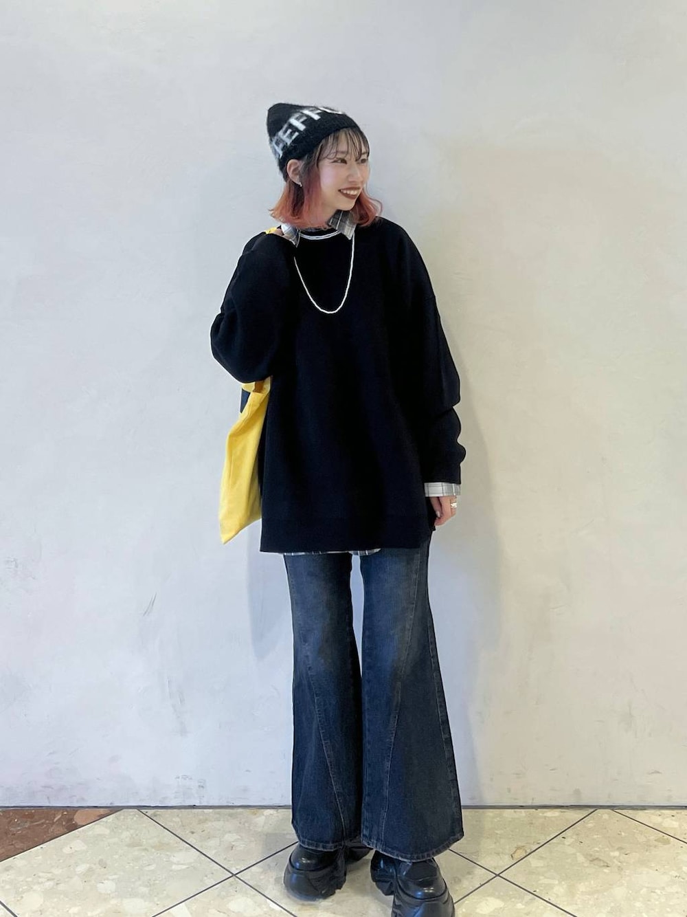 ブラック系のブーツ、ブラック系のニット/セーター、ブルー系のデニムパンツを着用したレディースの秋コーディネートの1枚目の写真