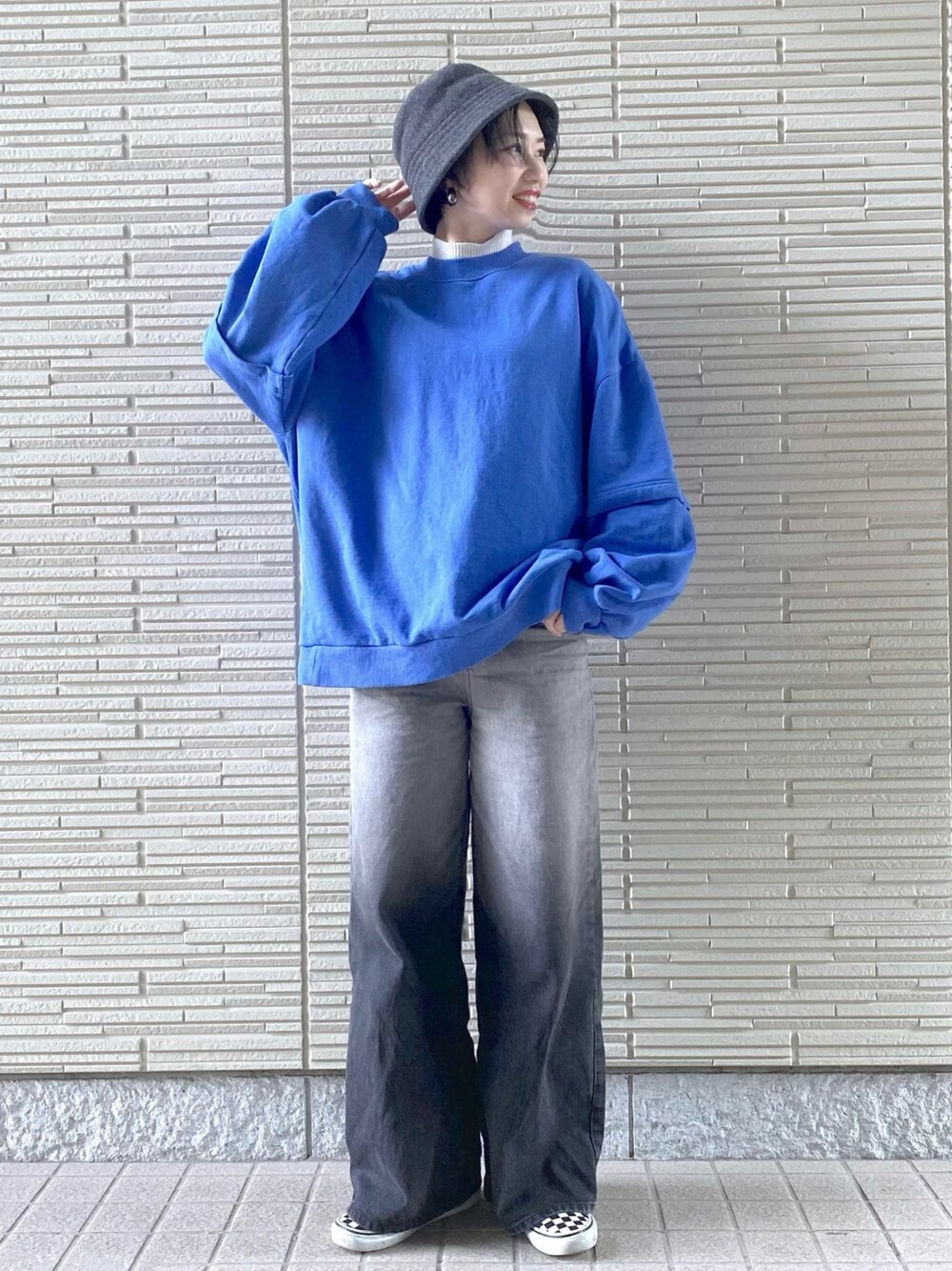 ブラック系のデニムパンツ、ブルー系のスウェット、ホワイト系のニット/セーターを着用したレディースの冬コーディネートの1枚目の写真