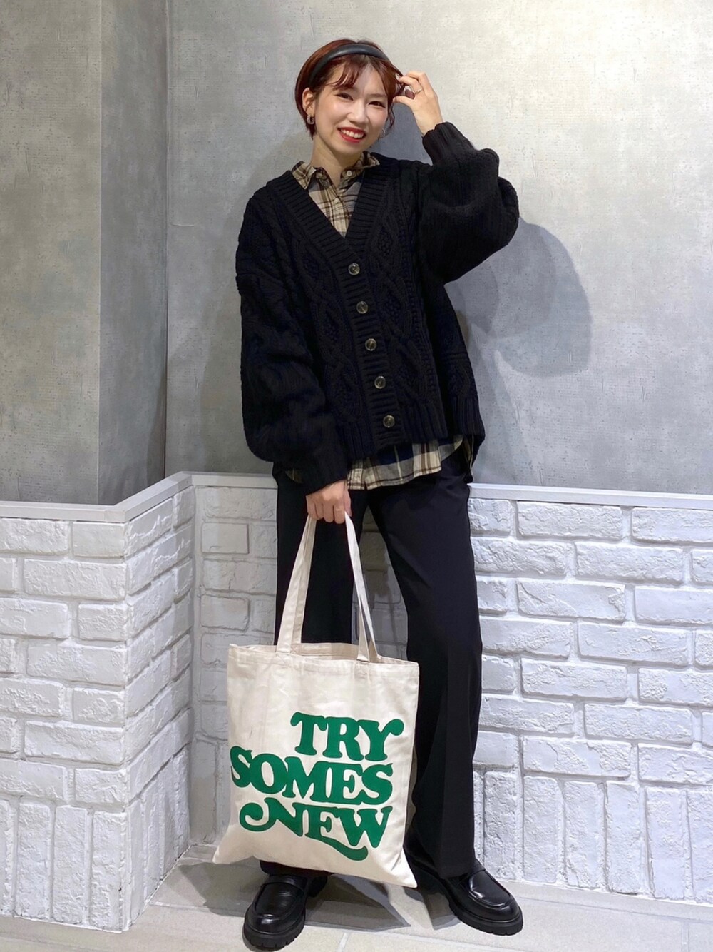 ホワイト系のトートバッグ、ブラック系のローファー、ブラック系のスラックスを着用したレディースの秋コーディネートの1枚目の写真