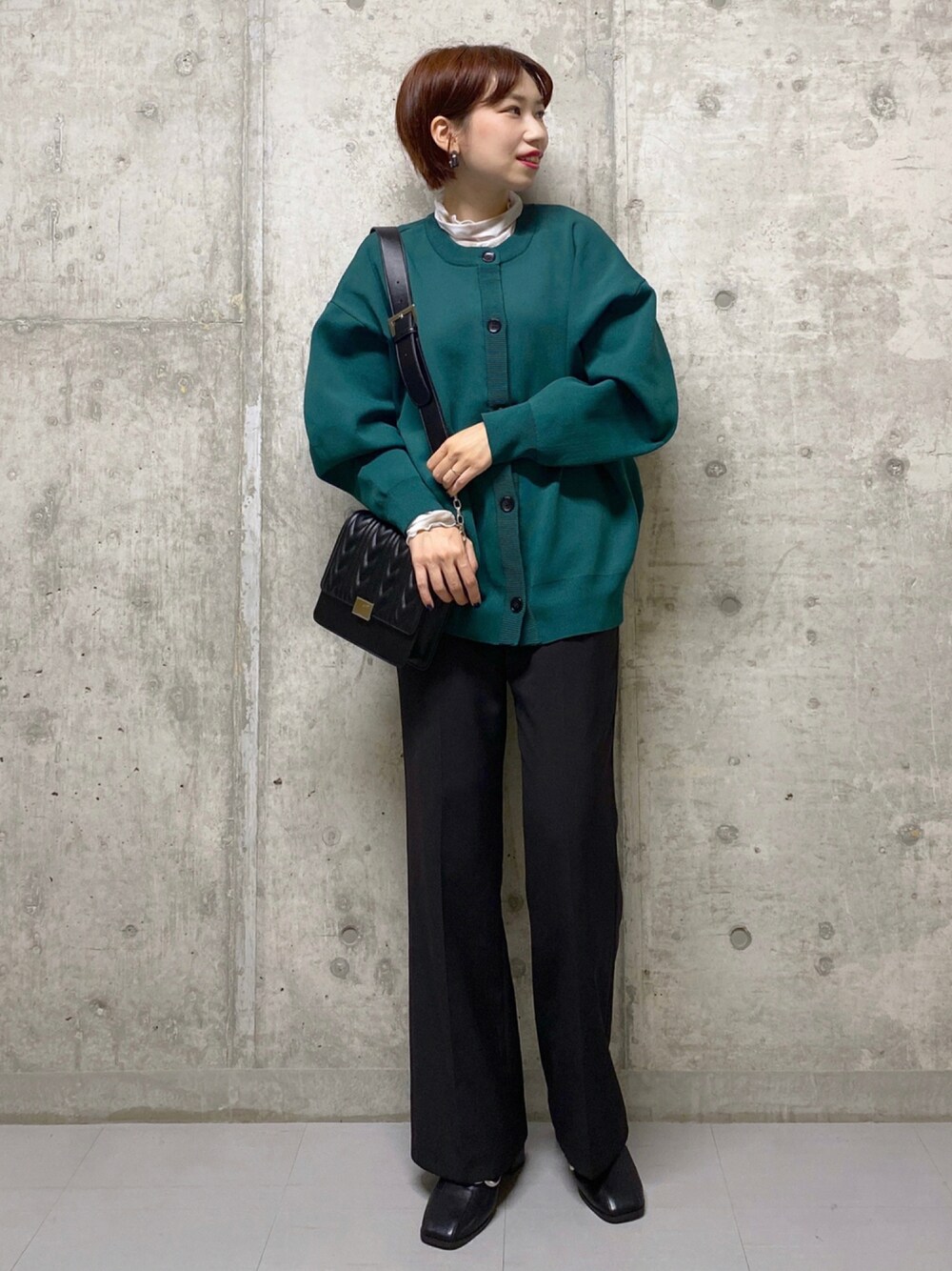 ブラック系のスラックス、ブラック系のサンダル、ブラック系のショルダーバッグを着用したレディースの秋コーディネートの1枚目の写真