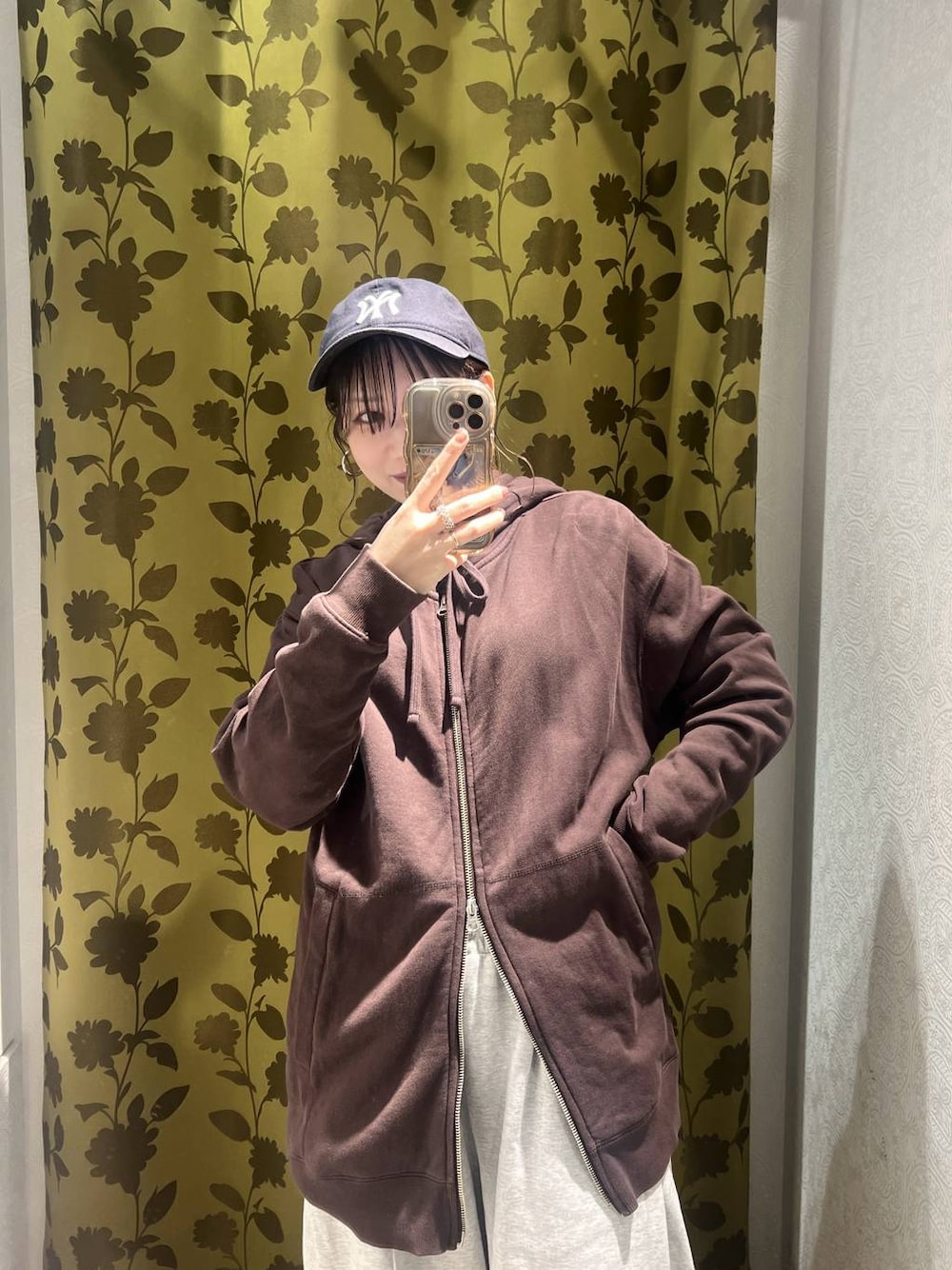 ブラウン系のパーカー、グレー系のスウェットパンツ、ホワイト系のスマホケース/カバーを着用したレディースの冬コーディネートの1枚目の写真