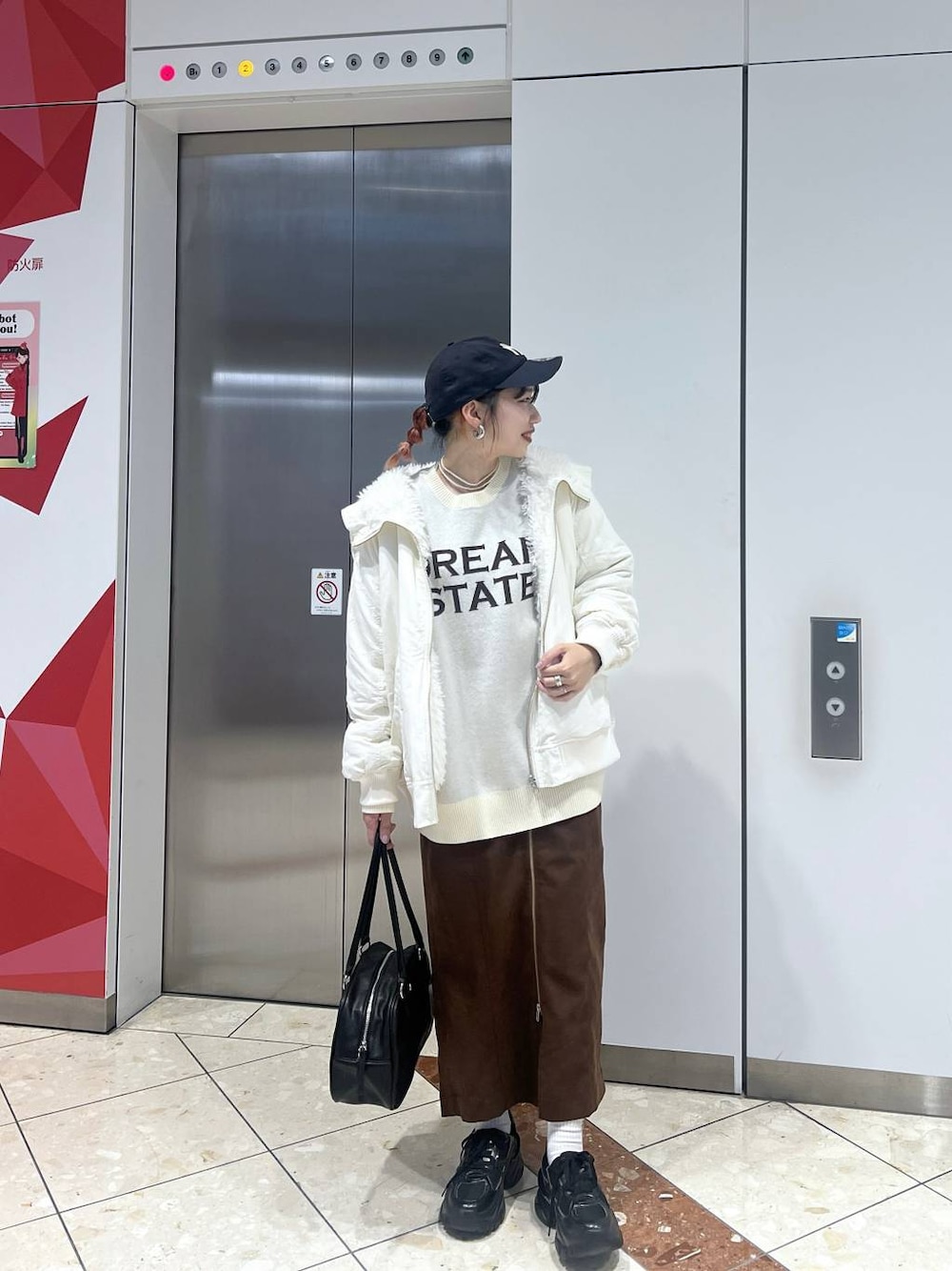 ブラック系のスニーカー、ホワイト系のブルゾン、ブラック系のボストンバッグを着用したレディースの秋コーディネートの1枚目の写真