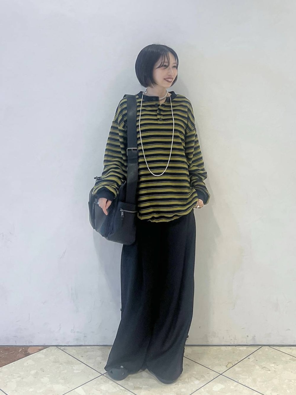 ブルー系のTシャツ/カットソー、ブラック系のスラックス、ブラック系のボストンバッグを着用したレディースの秋コーディネートの1枚目の写真