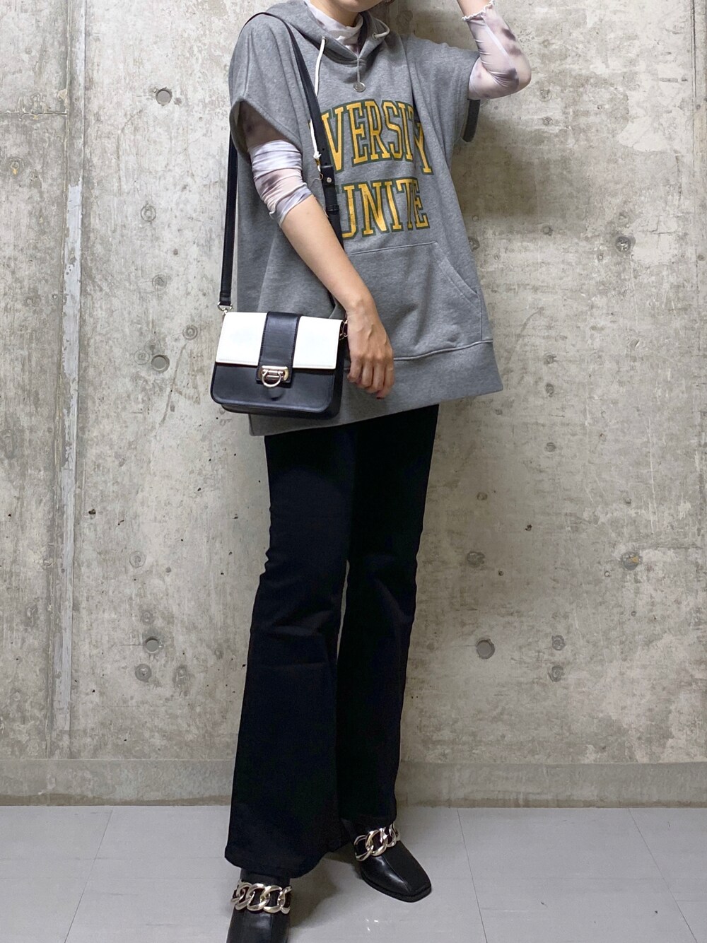 ブラック系のデニムパンツ、ブラック系のサンダル、ホワイト系のショルダーバッグを着用したレディースの夏コーディネートの1枚目の写真