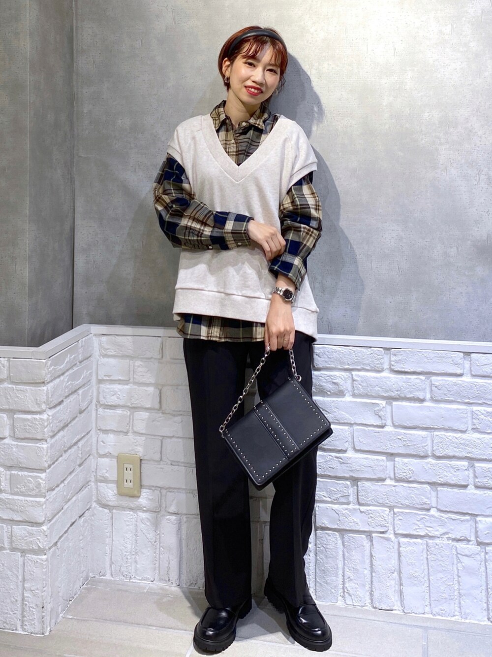 ブラック系のスラックス、ブラック系のローファー、ブラック系のショルダーバッグを着用したレディースの秋コーディネートの1枚目の写真