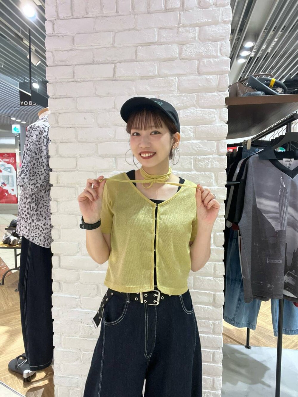 イエロー系のTシャツ/カットソー、ブルー系のデニムパンツ、ブラック系のキャップを着用したレディースの夏コーディネートの1枚目の写真