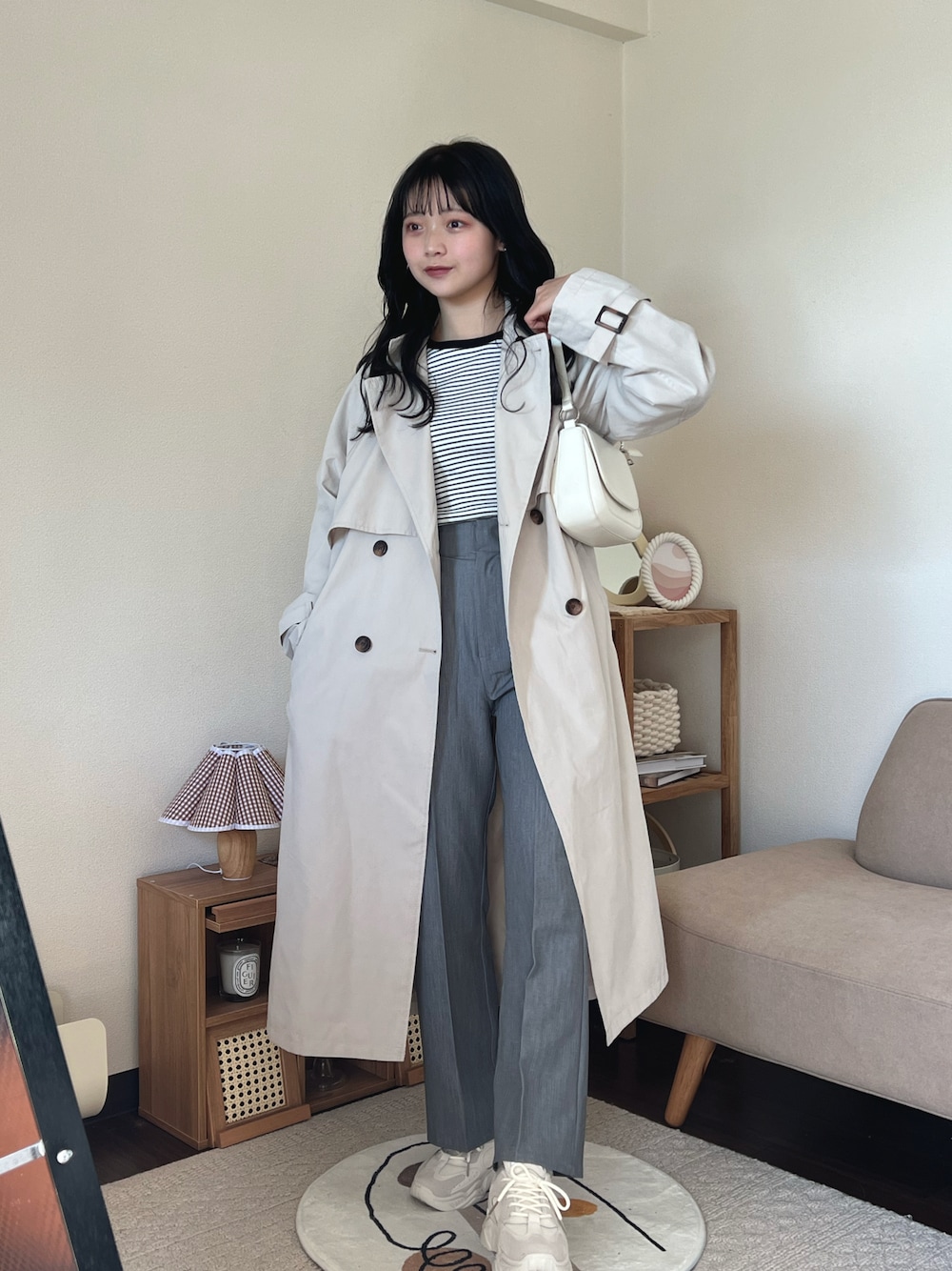 ブラック系のTシャツ/カットソー、グレー系のスラックス、ベージュ系のスニーカーを着用したレディースの春コーディネートの1枚目の写真