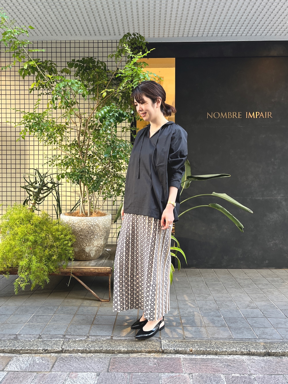 「休日コーデ、オトナ女子、大人ガーリー、ブラック、オーバーサイズ、春、高身長コーデ、ニットスカート、プリントスカート、モノトーンコーデ」｜「NOMBRE IMPAIRの【Stilmoda】バックストラップミュール（パンプス、ブラック系）」を使った、tsurumi.さん（レディース・165cm）の冬コーディネートの1枚目の写真