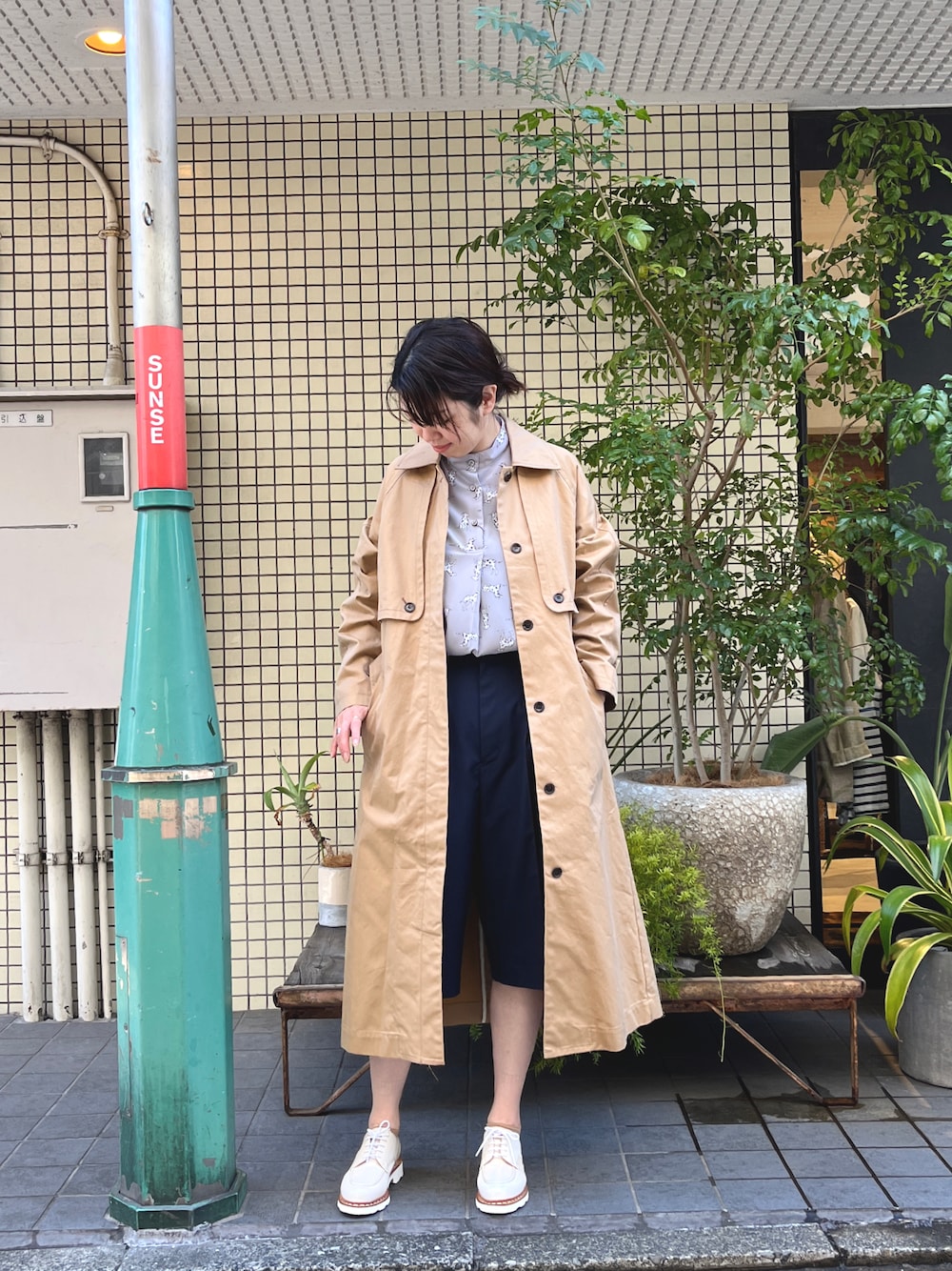 「春コーデ、柄ブラウス、高身長コーデ、ハーフパンツ、コート、大人カジュアル、オフィスカジュアル、ベージュアウター、きれいめカジュアル」｜「NOMBRE IMPAIRのダルメシアン　スタンドネックブラウス（シャツ/ブラウス、グレー系）」を使った、tsurumi.さん（レディース・165cm）の春コーディネートの1枚目の写真