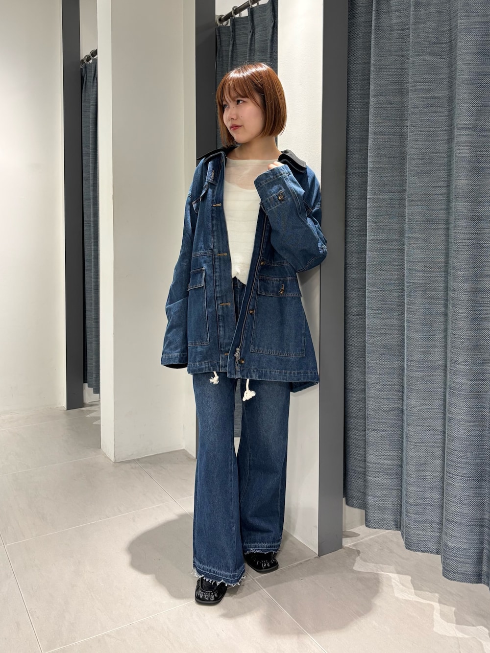 ブルー系のカバーオール、ブルー系のデニムパンツ、ブラック系のローファーを着用したレディースの秋コーディネートの1枚目の写真