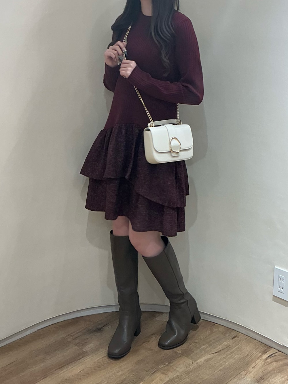 ブラック系のワンピース、ブラック系のブーツ、ブラック系のバッグを着用したレディースの秋コーディネートの1枚目の写真