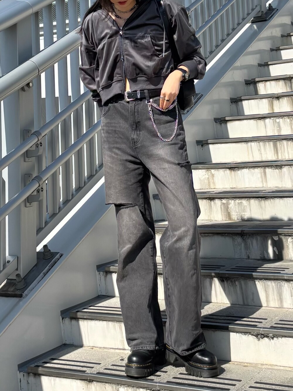 グレー系のパーカー、ブラック系のデニムパンツ、ブラック系のショルダーバッグを着用したレディースの秋コーディネートの1枚目の写真