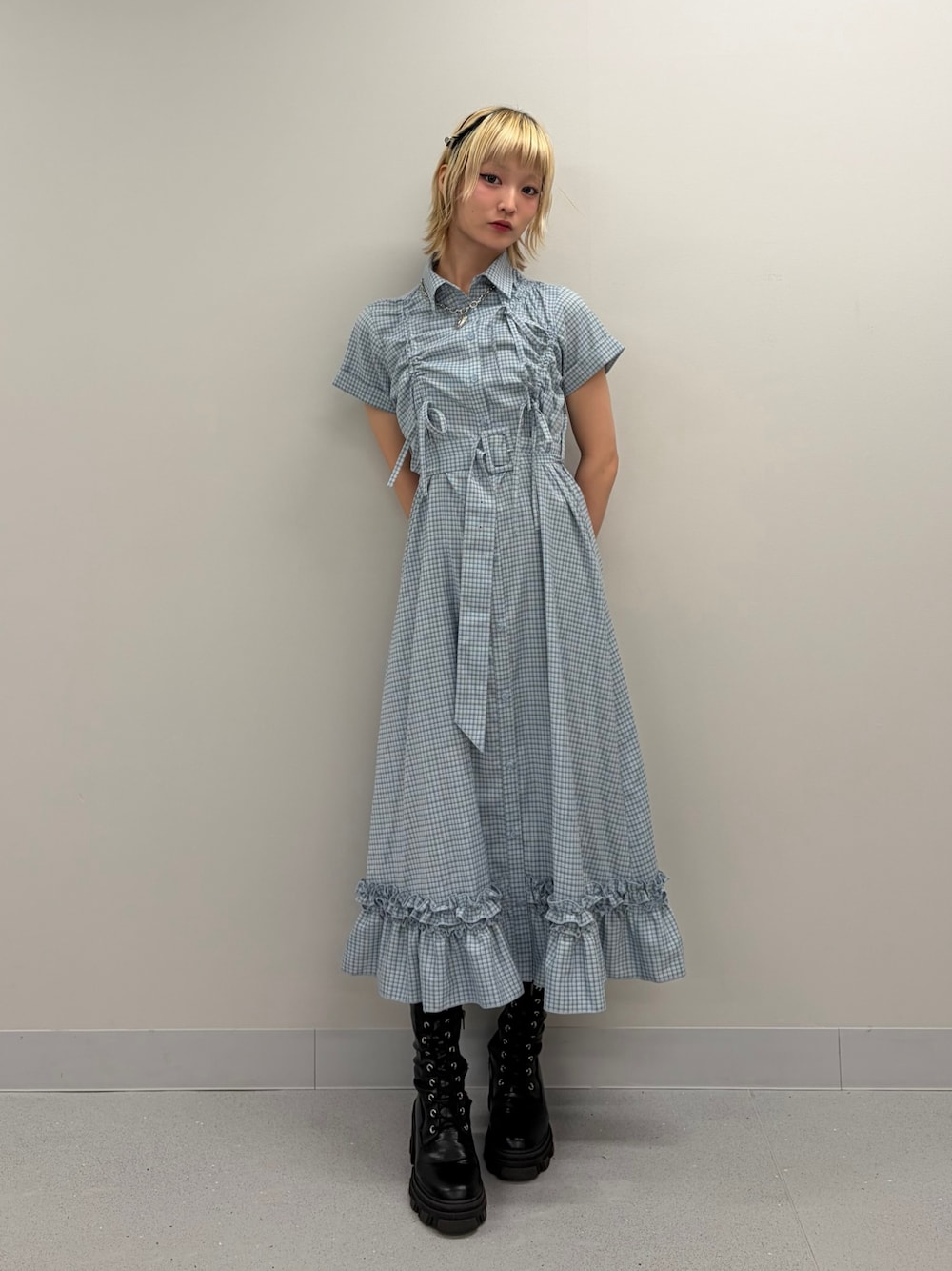 ブルー系のワンピース、ブラック系のブーツを着用したレディースの春コーディネートの1枚目の写真