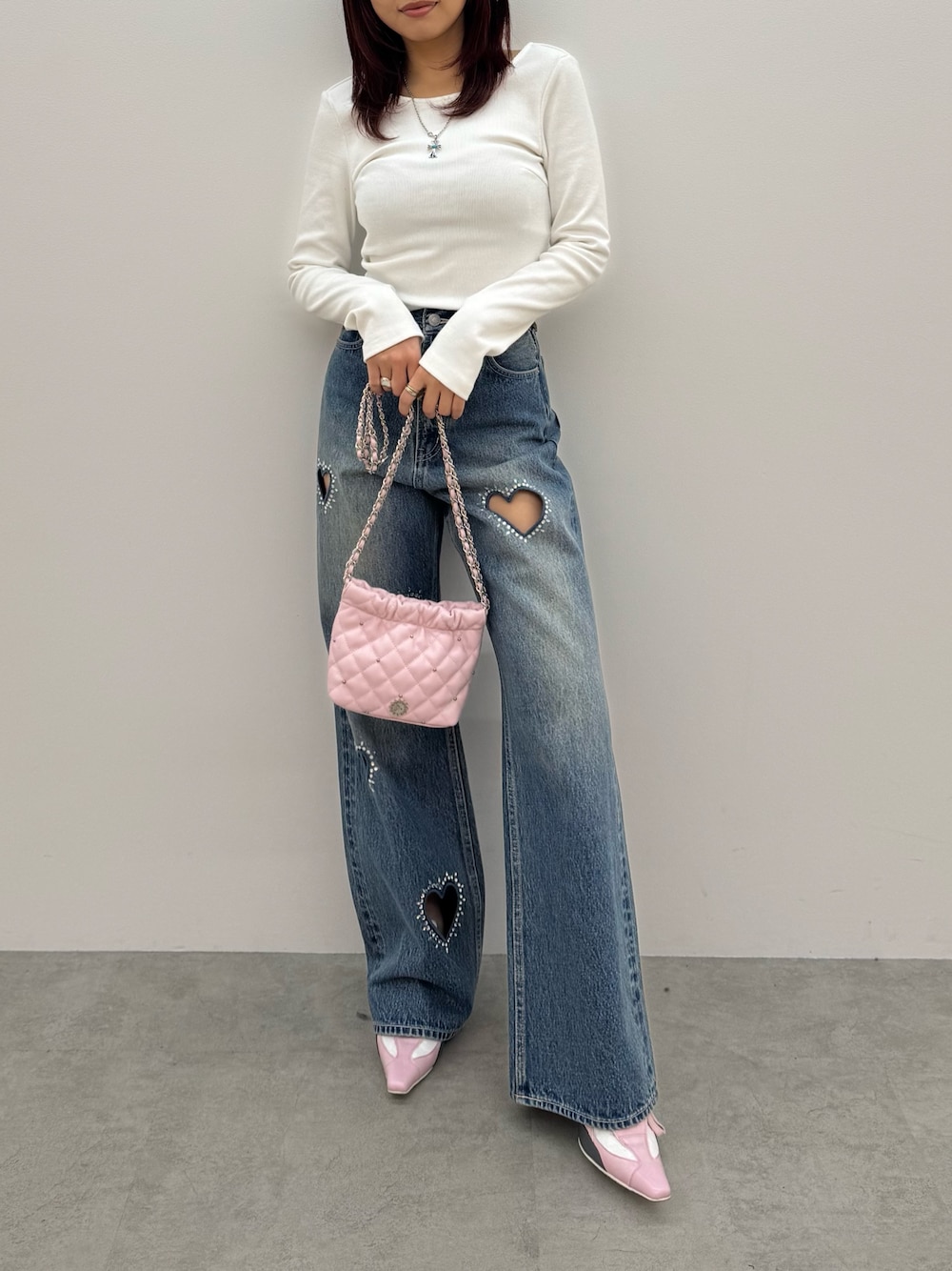 ホワイト系のTシャツ/カットソー、ブルー系のデニムパンツ、ピンク系のショルダーバッグを着用したレディースの冬コーディネートの1枚目の写真