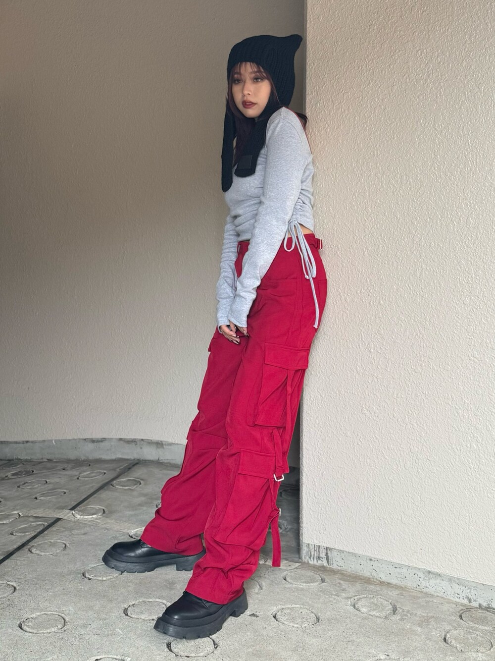 グレー系のTシャツ/カットソー、レッド系のカーゴパンツ、ブラック系のブーツを着用したレディースの秋コーディネートの1枚目の写真