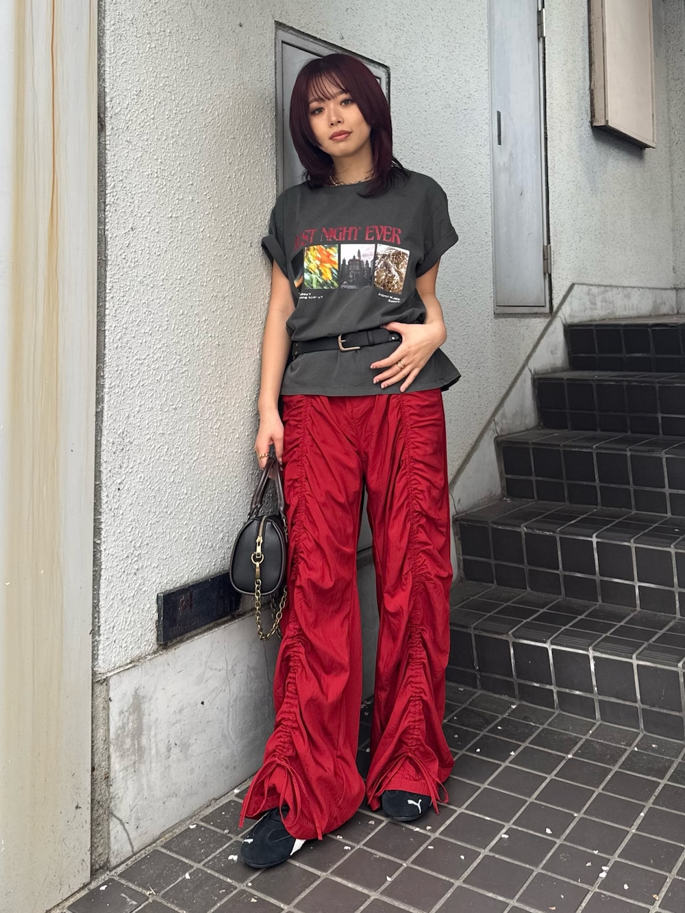 ブラック系のTシャツ/カットソー、ブラック系のショルダーバッグ、レッド系のその他パンツを着用したレディースの春コーディネートの1枚目の写真
